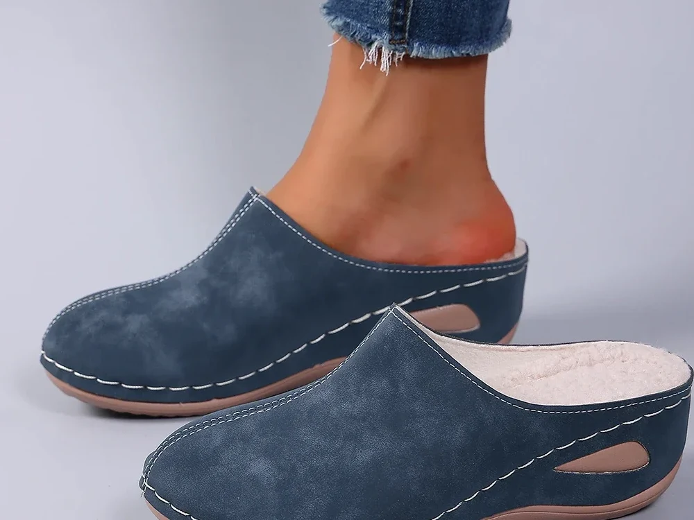 Le pantofole blu indossate con i jeans: sembrano scarpe basse